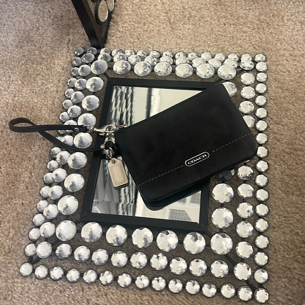 Coach black wristlet with white tag.